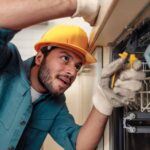 close-up-of-handyman-in-special-clothing-repairing-dishwasher-in-modern-kitchen.jpg